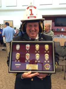 Mayor of Chaska, Mark Windschitl holds up his Saint Louis Park firefighter's badges that he collected throughout the years.